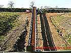 Conveyor carrying extracted material running under a road