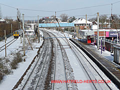 snow covered Hatfield railway station from overhead bridge across tracks