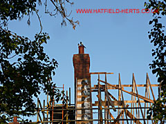 Readymade brick stack and clay pot being installed on a house under construction