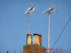 Brick stack with two tv aerials and three pots visible - mix of round and square, terracotta and buff or stoneware
