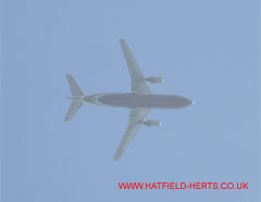 Twin engine passenger jet with dark blue underside fuselage and silver wings