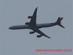 Four engine passenger jet, white fuselage with red tail and engine cowlings